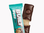 A BUILT cookie dough chunk puff shown inside and outside of the wrapper on a white background.
