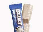 A BUILT cookies and cream puff shown both inside and outside of the wrapper on a white background.
