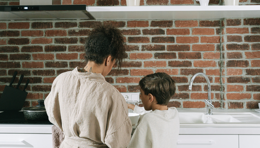 mother standing next to her young son at the kitchen counter