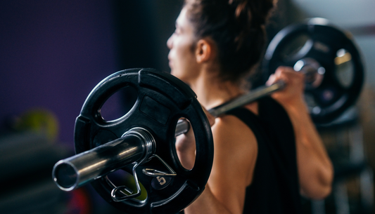 woman with a barbell and weights across her back