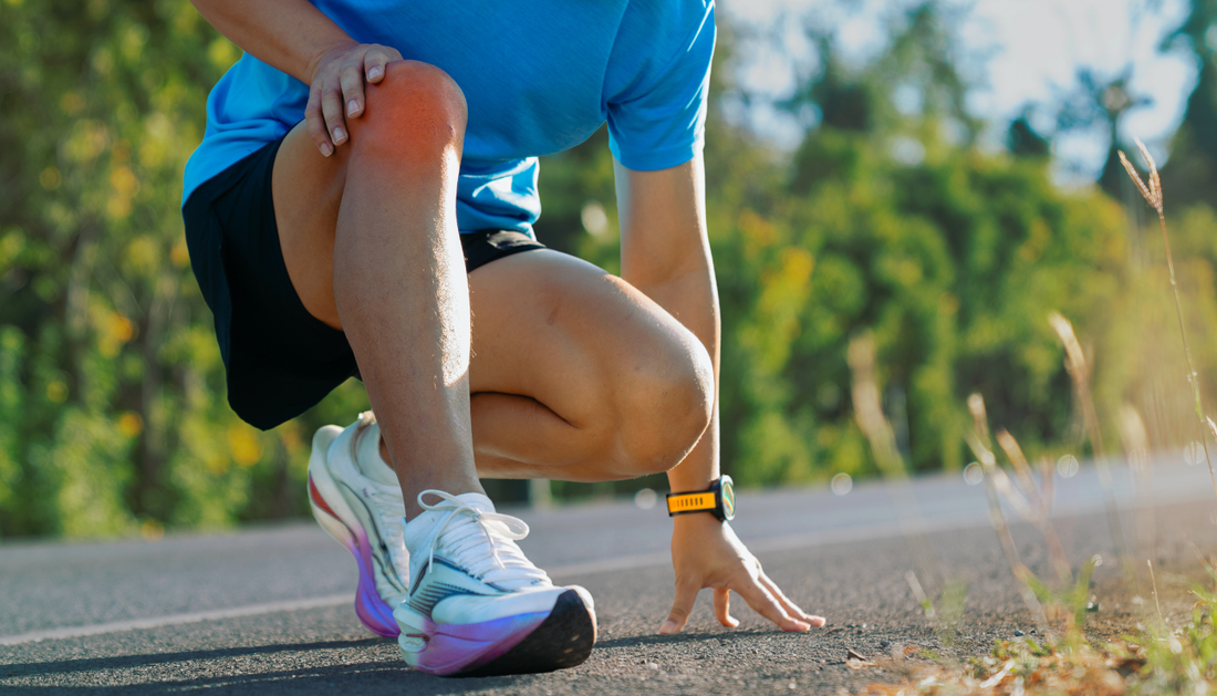 distance runner squatting down on the side of the road