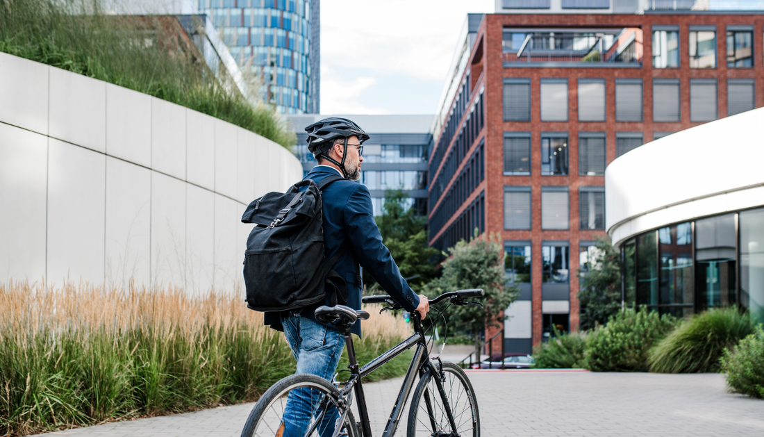A cyclist commuting through a city street with a backpack, representing an active, busy lifestyle.