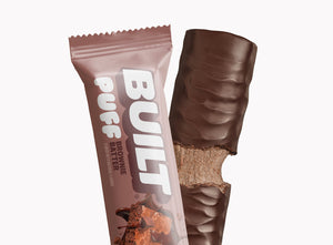 A BUILT brownie batter puff shown both inside and outside of the wrapper on a white background.