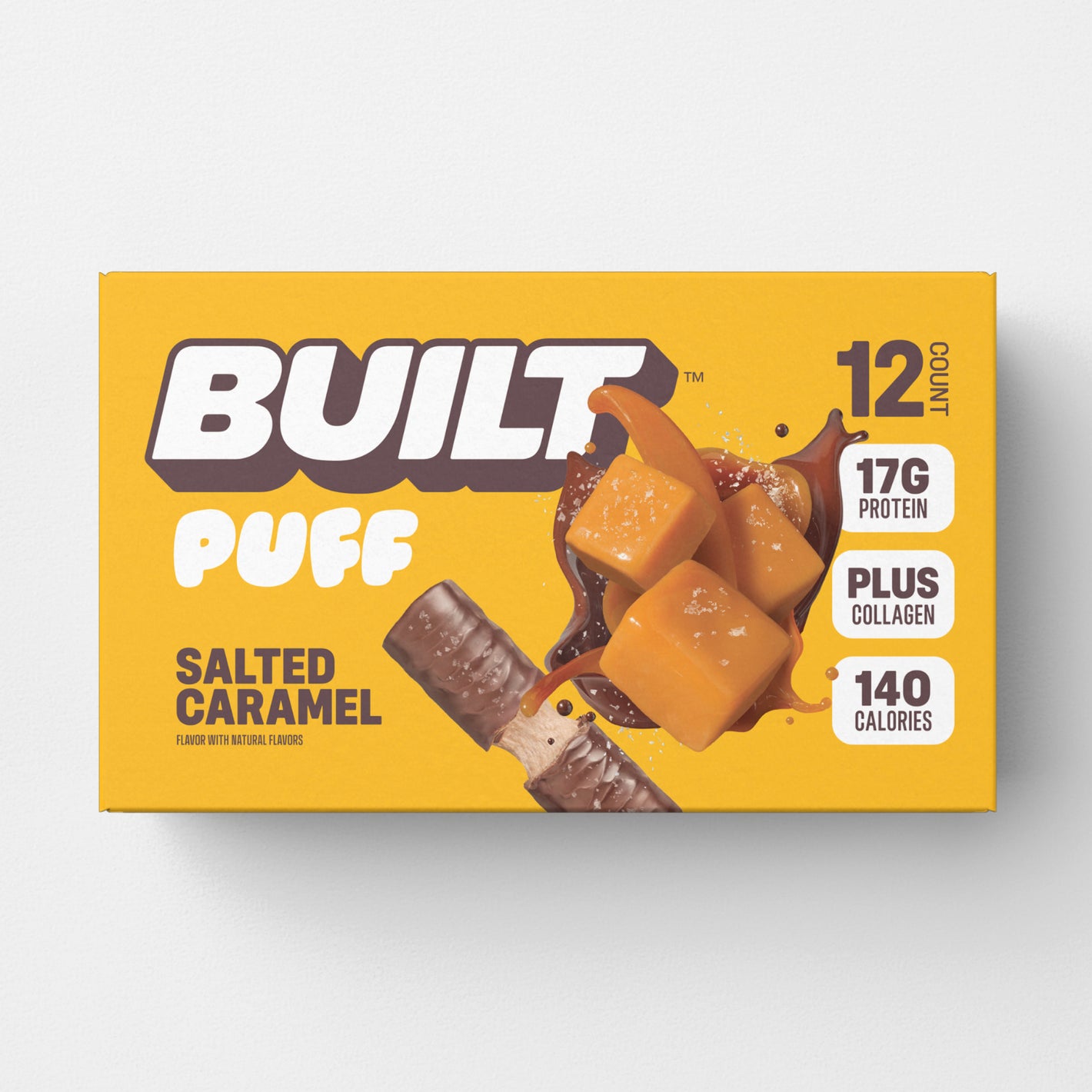 A yellow box of 12 BUILT salted caramel puffs on a white background.