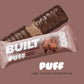 A BUILT brownie batter puff shown both inside and outside of the wrapper on a light brown background, featuring it's marshmallowy inside.